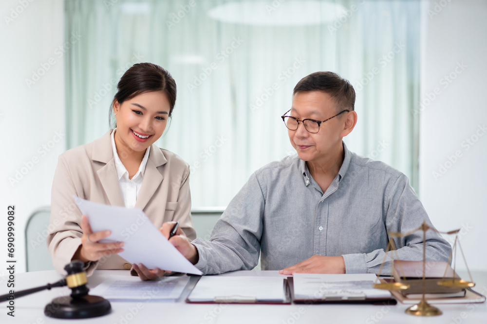 Senior businessman pointing on contract to asking about term and legal agreement with female lawyer Senior businessman pointing on contract to asking about term and legal agreement with female lawyer
