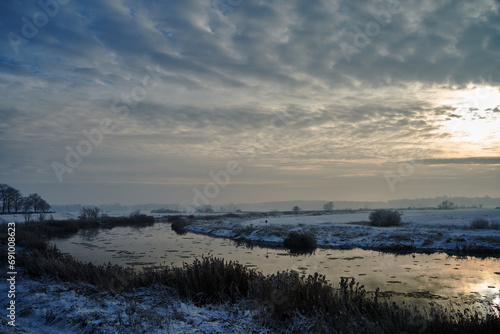 floes on the Warta River and snow-covered bushes and trees during winter