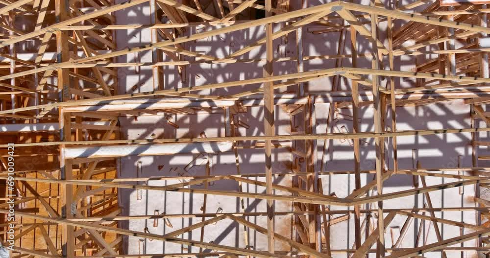 At new residential building, wood roofing rafters are hung from joist ...