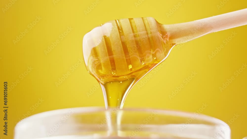Honey dripping. Dipping honey with honey scoop in glass jar. Healthy organic food. Thick honey dripping from wooden spoon. Close-up in 4K, UHD Honey dripping. Dipping honey with honey scoop in glass jar. Healthy organic food. Thick honey dripping from wooden spoon. Close-up in 4K, UHD