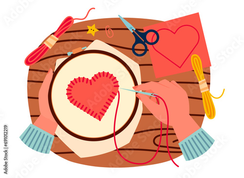 Top view on table with hands holding embroidery hoop with heart embroidery.  Sewing red heart , DIY. Cartoon vector illustration of hands sewing felt red heart decoration on cloth.