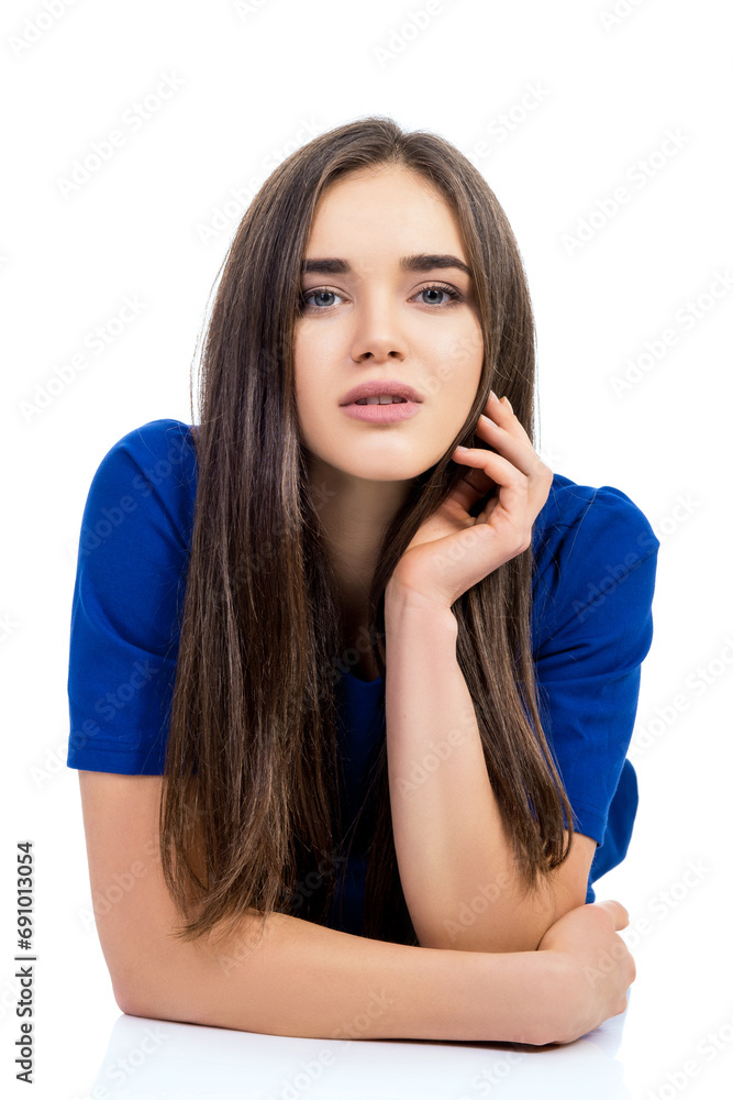 Naklejka premium Charming young woman holding hands neat to her face posing over white background