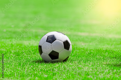An empty soccer ball on the grass Outdoors with a blurred green garden background  park on a sunny day. warm with sunset light