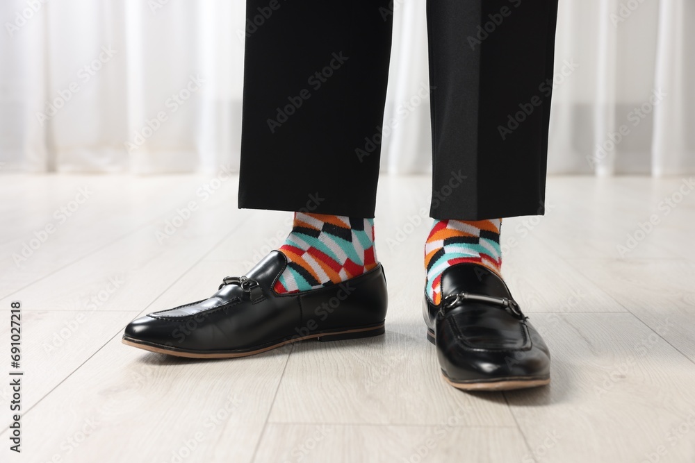 Man in stylish colorful socks, shoes and pants indoors, closeup
