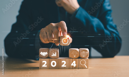 Businessman setup business trend 2024 strategy action target, Start calendar 2024 plan concept. Person Goal challenge person planning growth New year 2024, profit income, digital marketing. photo