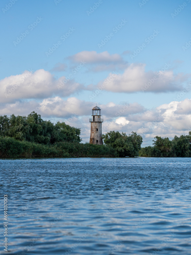 Old abandoned lighthouse on river close to sea