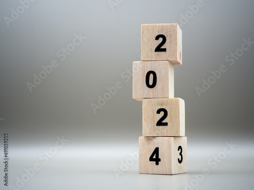 Flipping the year 2023 to 2024 on wooden blocks in preparation for the new year change.