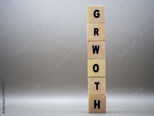 The word GROWTH written on wooden cubes on a gray background.