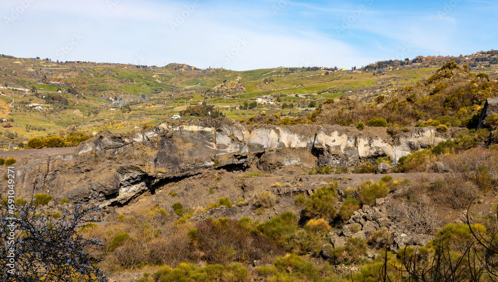 Panoramic view of western slope of Mount Etna volcano with lava eruption formations in Bronte town over Simeto river valley in Catania region in Sicily, Italy
