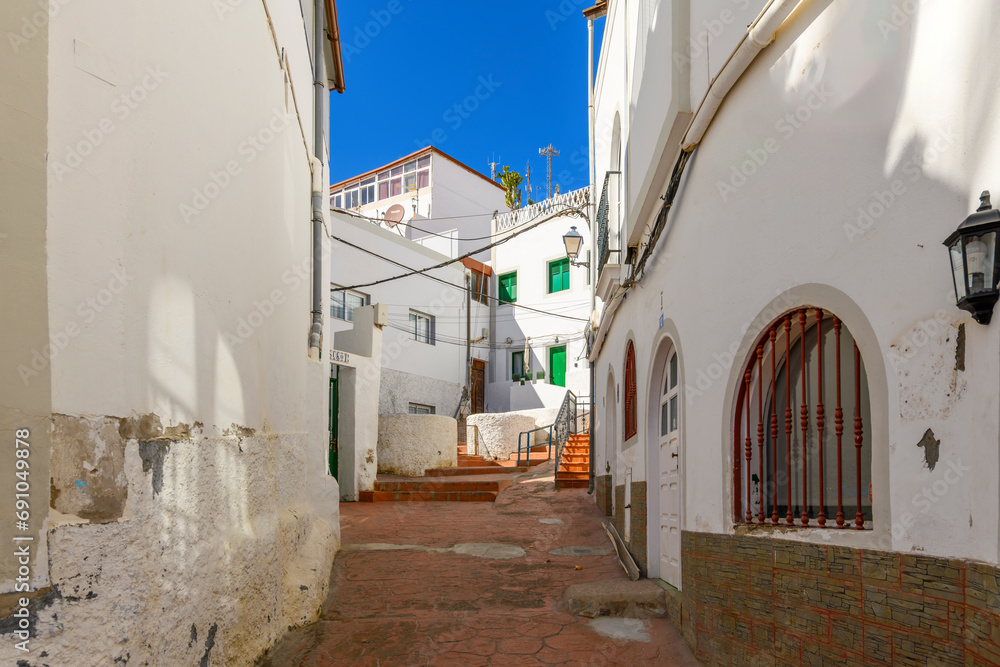 A narrow street in the hillside old town of the whitewashed fishing village of Puerto de Mogan Spain on the Canary island of Gran Canaria.