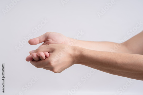 Young asian man suffer from wrist pain and pressing hand to sore spot, isolated on white background. Distension trauma, luxation and chronic arthritis, carpal tunnel syndrome and sport injury photo