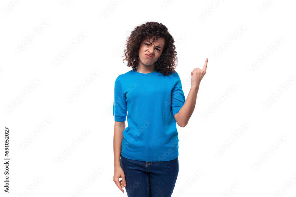 a bright curly woman dressed in a blue summer jacket actively gesticulates against the background with copy space. advertising concept a bright curly woman dressed in a blue summer jacket actively gesticulates against the background with copy space. advertising concept