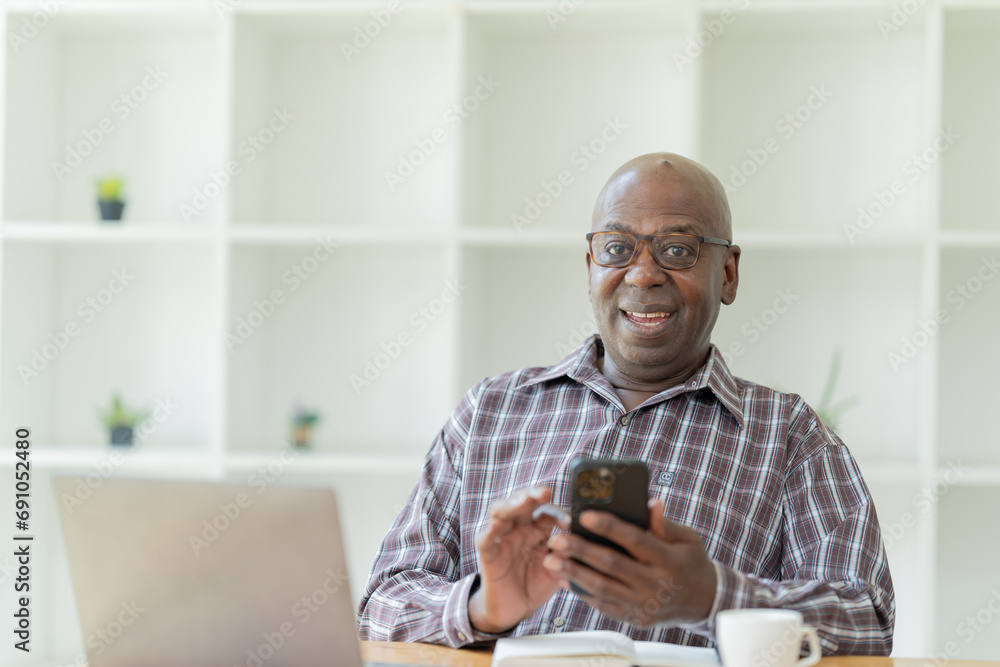 Happy of American professional businessman, wearing glasses working on laptop, remote studying using computer looking at screen watching seminar webinar at home office. Happy of American professional businessman, wearing glasses working on laptop, remote studying using computer looking at screen watching seminar webinar at home office.