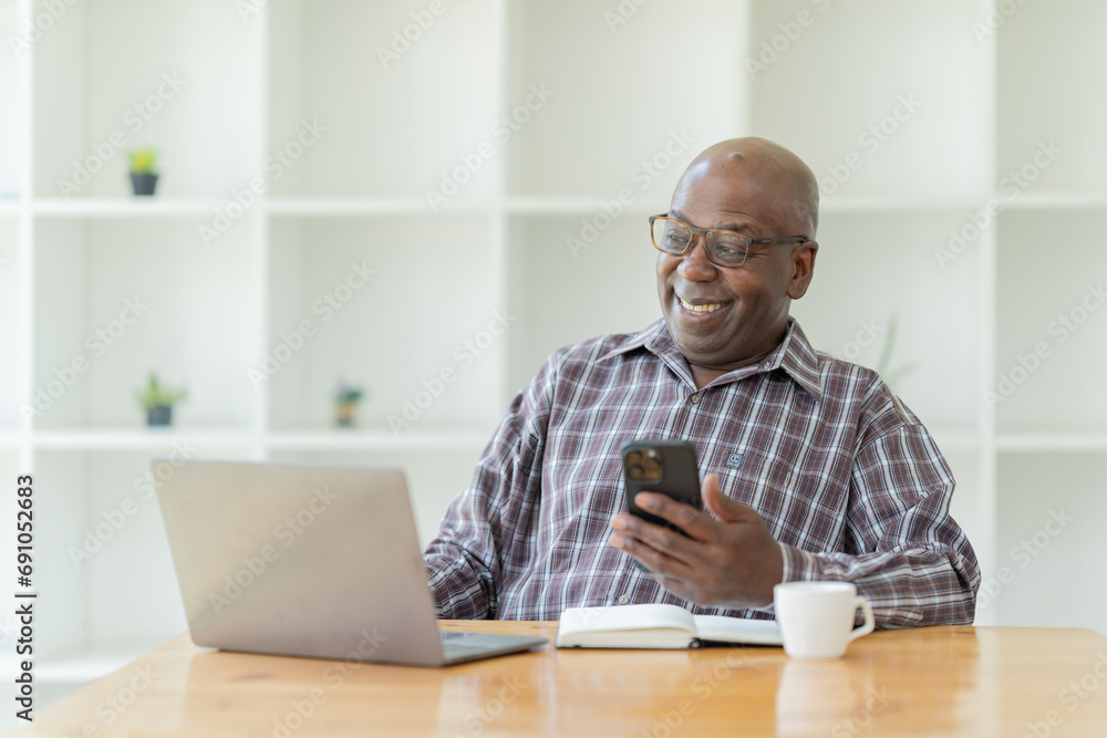 Portrait of happy African American small business owner. Millennial black smiling, sitting and using the laptop, and holding a cup of coffee work in modern office. Portrait of happy African American small business owner. Millennial black smiling, sitting and using the laptop, and holding a cup of coffee work in modern office.