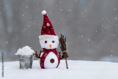 Christmas snowman on snowy background.Greeting card for Merry Christmas and New Year holidays. © Yuliya