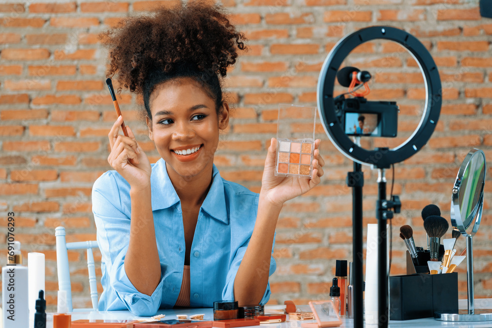 Woman influencer shoot live streaming vlog video review makeup crucial social media or blog. Happy young girl with cosmetics studio lighting for marketing recording session broadcasting online. - obrazy, fototapety, plakaty 