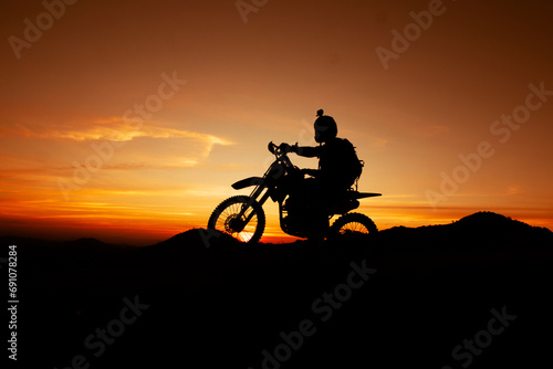 Fototapeta Naklejka Na Ścianę i Meble -  Sunset  on the mountain, Natural landscape, orange sky and Motocross silhouette  during sunset.