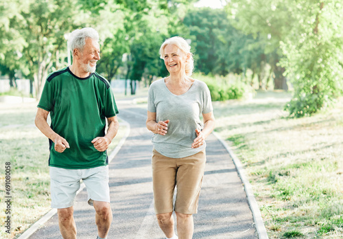 outdoor senior fitness woman man lifestyle active sport exercise healthy fit couple running jogging elderly mature having fun laughing talking together friend hug break