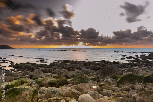 Sunset over the horizon of the ocean with a rocky shoreline in Sao Martinho do Porto, Portugal photo