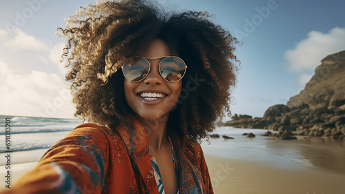 laughing african american girl taking selfie on camera on the beach © Sheviakova