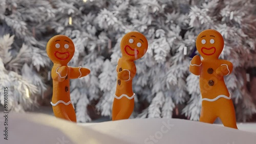Cute gingerbread cookies dancing in the snow photo
