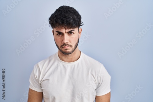 Hispanic man with beard standing over white background skeptic and nervous, frowning upset because of problem. negative person.
