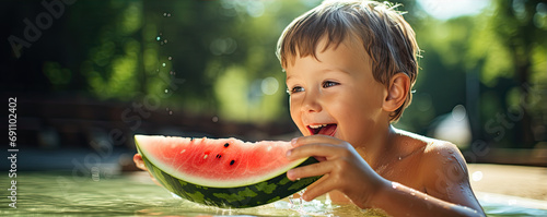 Happy boy is enjoying eating fresh watermelon during hot summer day.