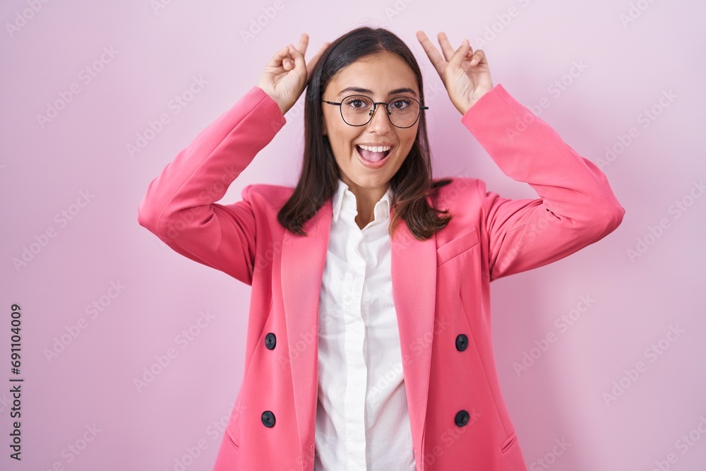 Young hispanic woman wearing business clothes and glasses posing funny and crazy with fingers on head as bunny ears, smiling cheerful Young hispanic woman wearing business clothes and glasses posing funny and crazy with fingers on head as bunny ears, smiling cheerful