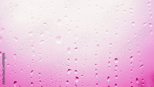 Condensation on window glass in frosty winter weather. Pink background in the form of small drops on the glass.