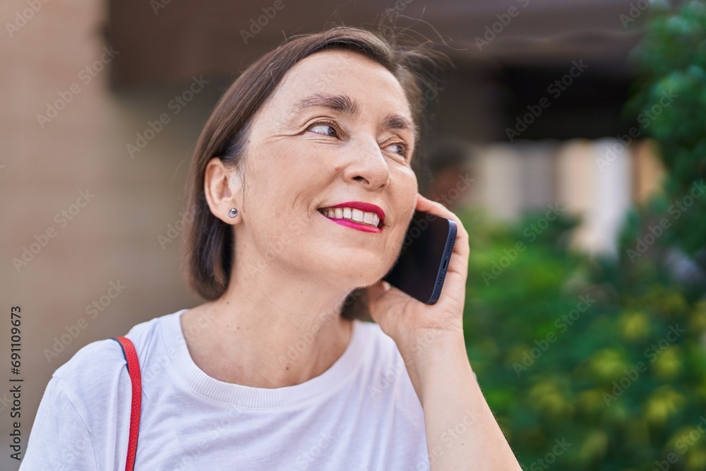 Middle age woman smiling confident talking on the smartphone at street Middle age woman smiling confident talking on the smartphone at street
