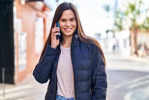 Young beautiful hispanic woman smiling confident talking on the smartphone at street © Krakenimages.com