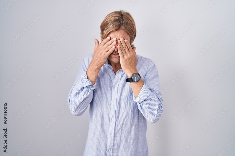 Caucasian man with mustache standing over white background rubbing eyes for fatigue and headache, sleepy and tired expression. vision problem Caucasian man with mustache standing over white background rubbing eyes for fatigue and headache, sleepy and tired expression. vision problem