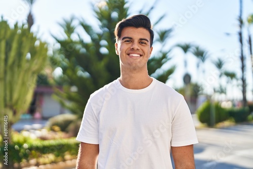 Young hispanic man smiling confident standing at street