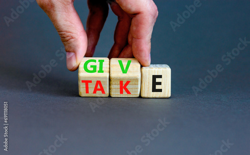 Give or take symbol. Concept word Give or Take on wooden cubes. Beautiful grey table grey background. Businessman hand. Business give or take concept. Copy space.