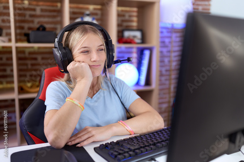 Young caucasian woman playing video games wearing headphones thinking looking tired and bored with depression problems with crossed arms.