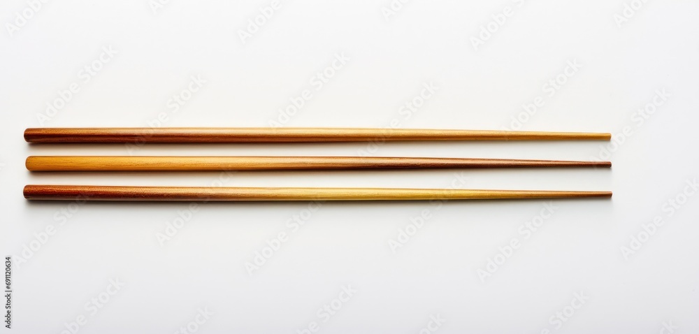  a pair of chopsticks sitting on top of a white table next to a pair of chopsticks.
