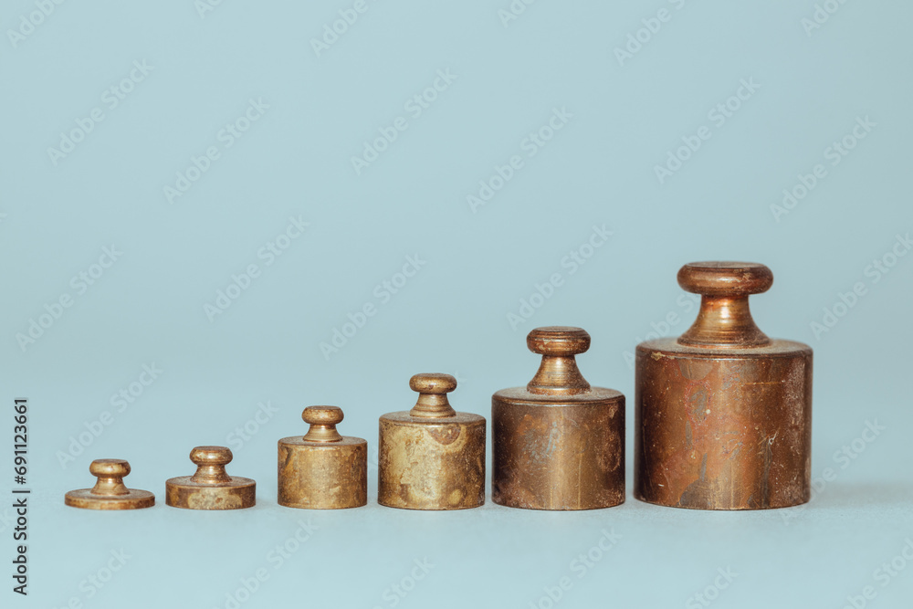 scale weights set from the smallest in a row, copy space, business concept, beautiful gray background scale weights set from the smallest in a row, copy space, business concept, beautiful gray background