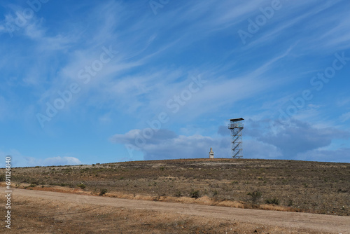 A lookout observation tower in the Blue Sky Hills of Portugal, in the middle of the countryside on a clear blue sky day.