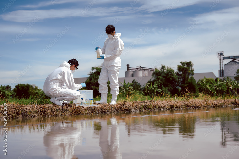 Factory scientists or biologists wear protective clothing while checking natural water sources, Chemical protection that may leak into natural water sources and Collecting water samples near farmland