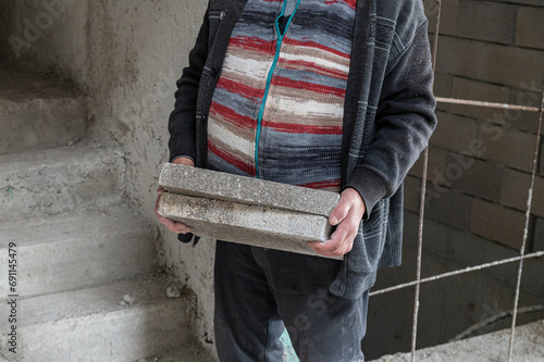 The construction foreman is carrying the briquettes.