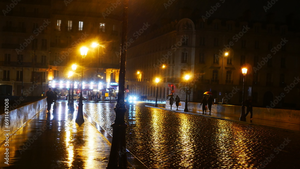 Promenade nocturne au bord de la Seine, ciel nuit noir, temps pluvieux, reflexion de lumière de lampadaires, beauté urbaine et historique, quelques marcheurs, environnement éclairé en jaune ou blanc, 