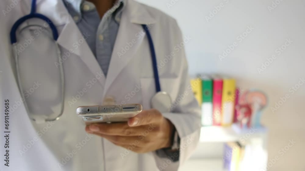 A doctor in a medical office with a mobile phone, utilizing telemedicine and new technologies for patient communication via mobile devices. Focus on health, illness, medication, and treatment via tele A doctor in a medical office with a mobile phone, utilizing telemedicine and new technologies for patient communication via mobile devices. Focus on health, illness, medication, and treatment via tele