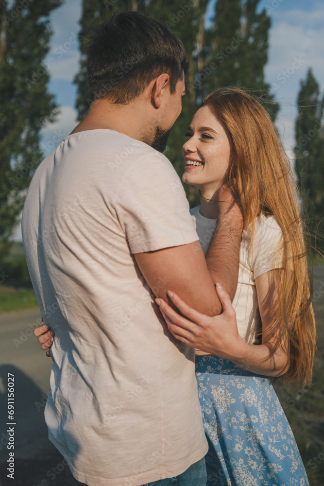Fototapeta premium Affectionate couple meeting in a place far from humanity, man and woman in love cuddling together, enjoying date in nature. Happiness concept.