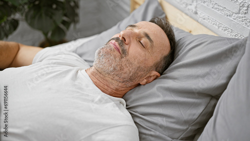 Exhausted, middle age man with grey hair, comfortably resting in the cozy comfort of his bedroom, laid back, relaxing on his soft bed, soundly asleep, escaping the morning rush indoors.