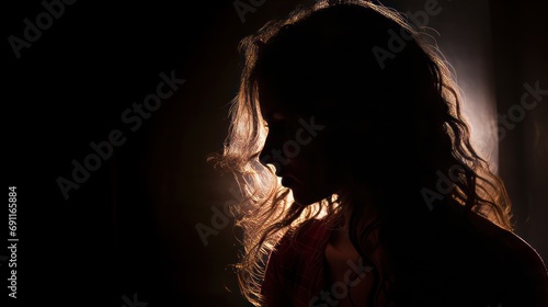 Silhouette of depressed  scared  sad woman with waving hair  back light.
