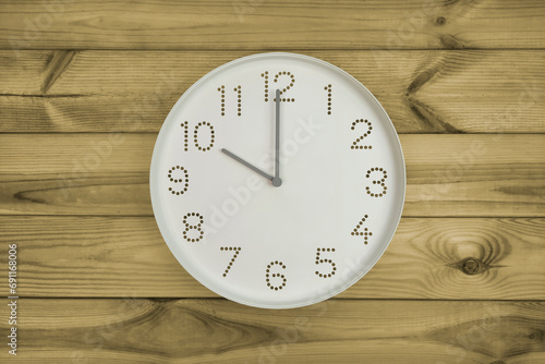 Ten o'clock. Time management or business concept. Plain white wall clock showing 10 am on a wooden background. Copy space. Opening or closing hours. Schedule or working, study hours.