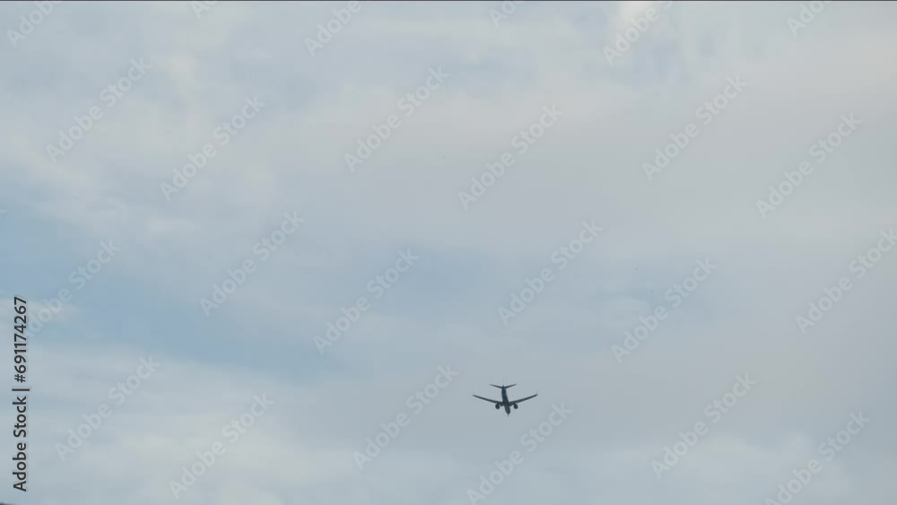 Airplane flying under the clouds, preparing to land Airplane flying under the clouds, preparing to land
