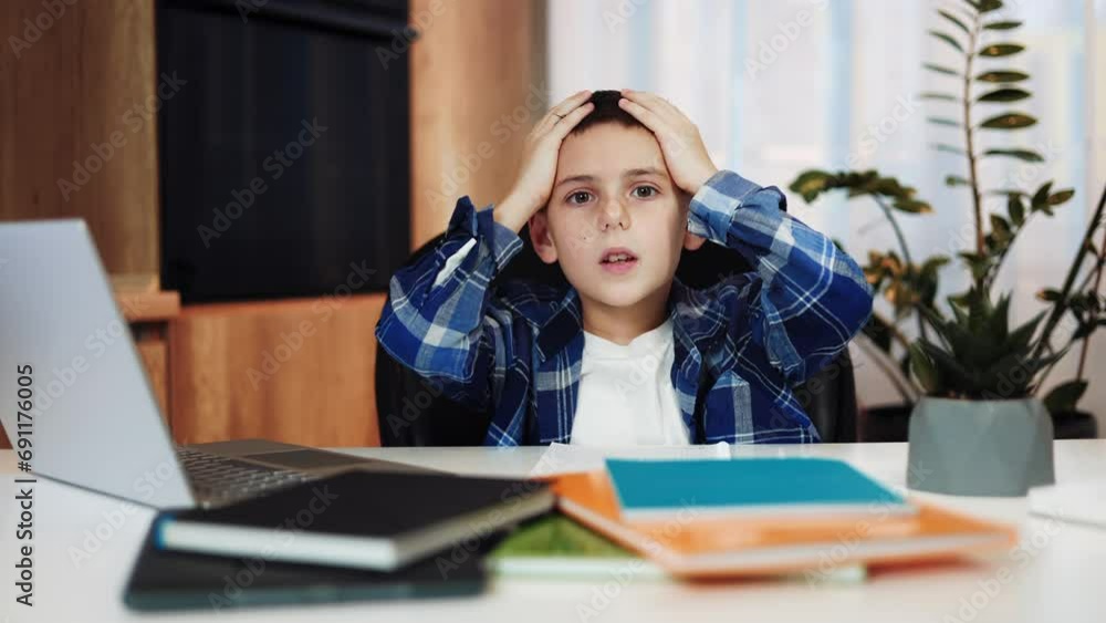 Disappointed young boy sitting in living room making surprised facial ...