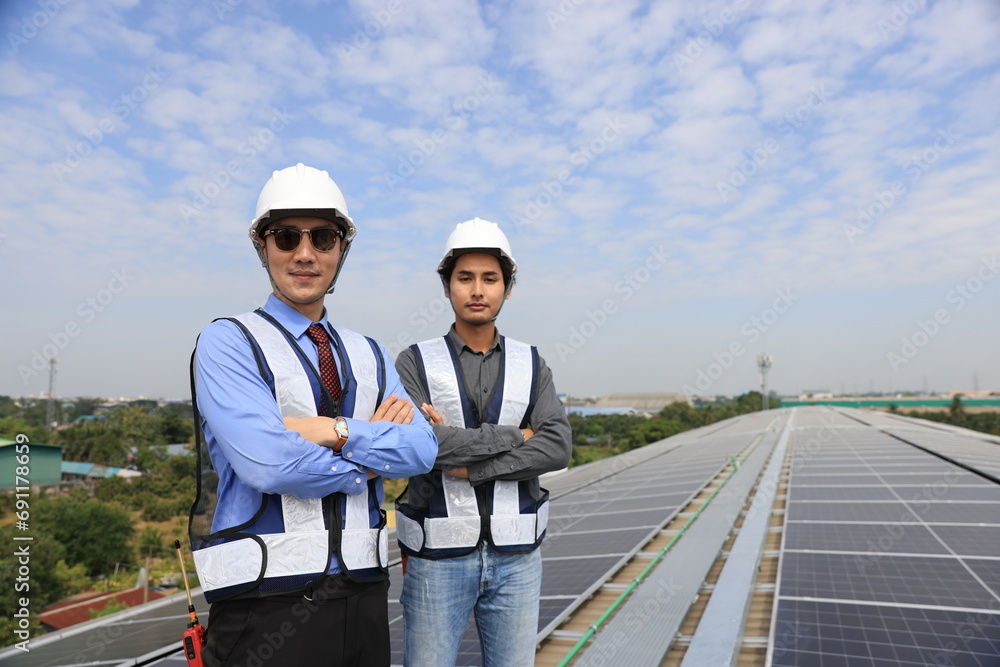Two men engineer with plan wearing safety vests talking on the construction site of the solar roof Two men engineer with plan wearing safety vests talking on the construction site of the solar roof