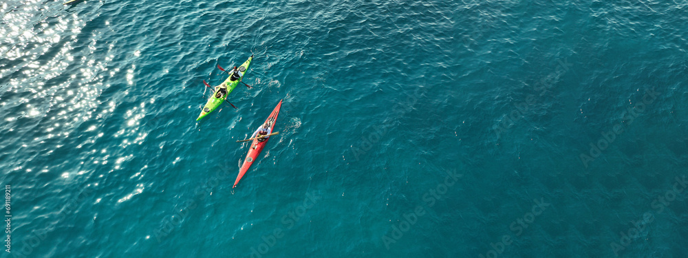 Aerial drone ultra wide photo of athletes competing with rowing in sport canoe in deep emerald paradise exotic island bay - obrazy, fototapety, plakaty 